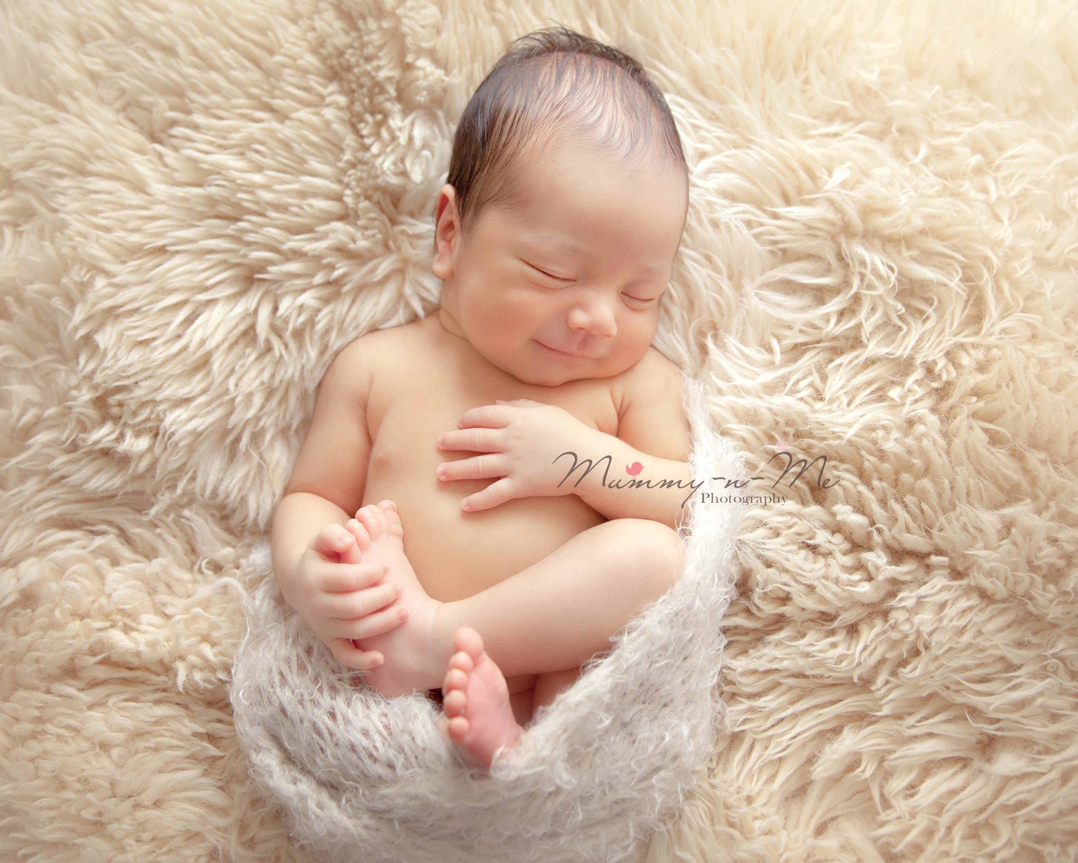 newborn boy lying on fur brisbane newborn photographer