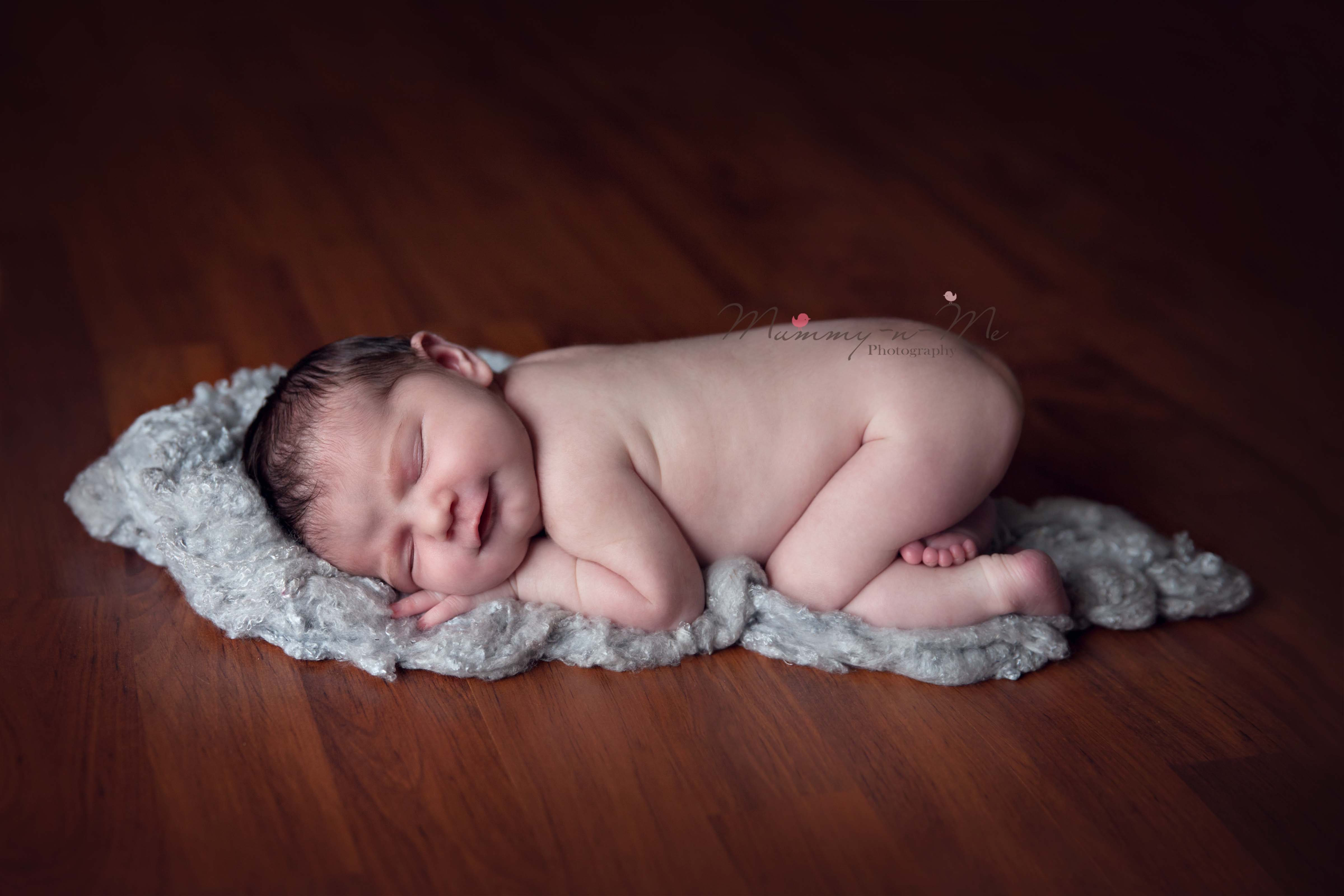 Newborn girl on rug on timber floor Brisbane Newborn Family Baby Cake Smash Photographer