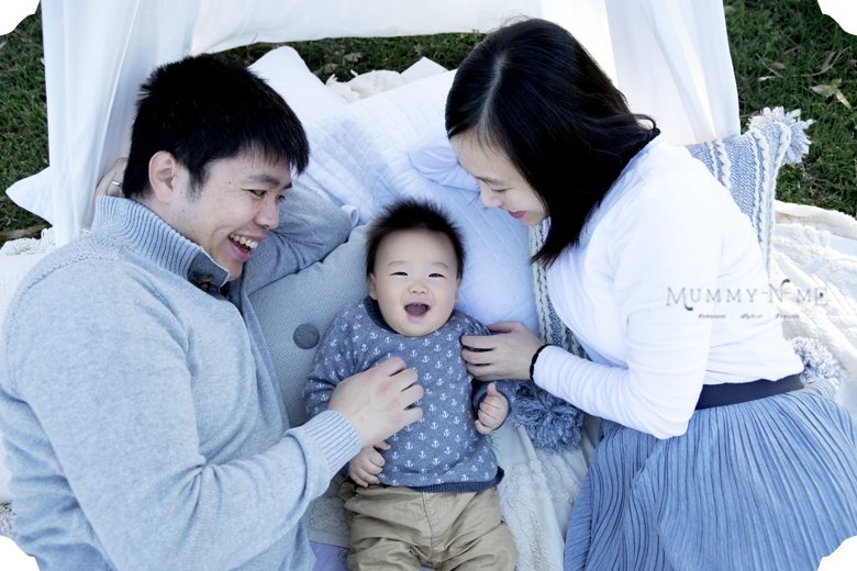 giggling baby at the park with his parents