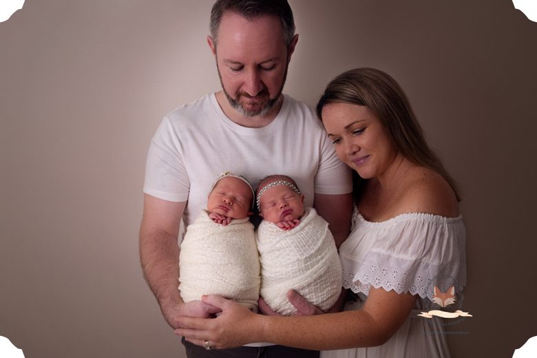 newborn twin girls with parents