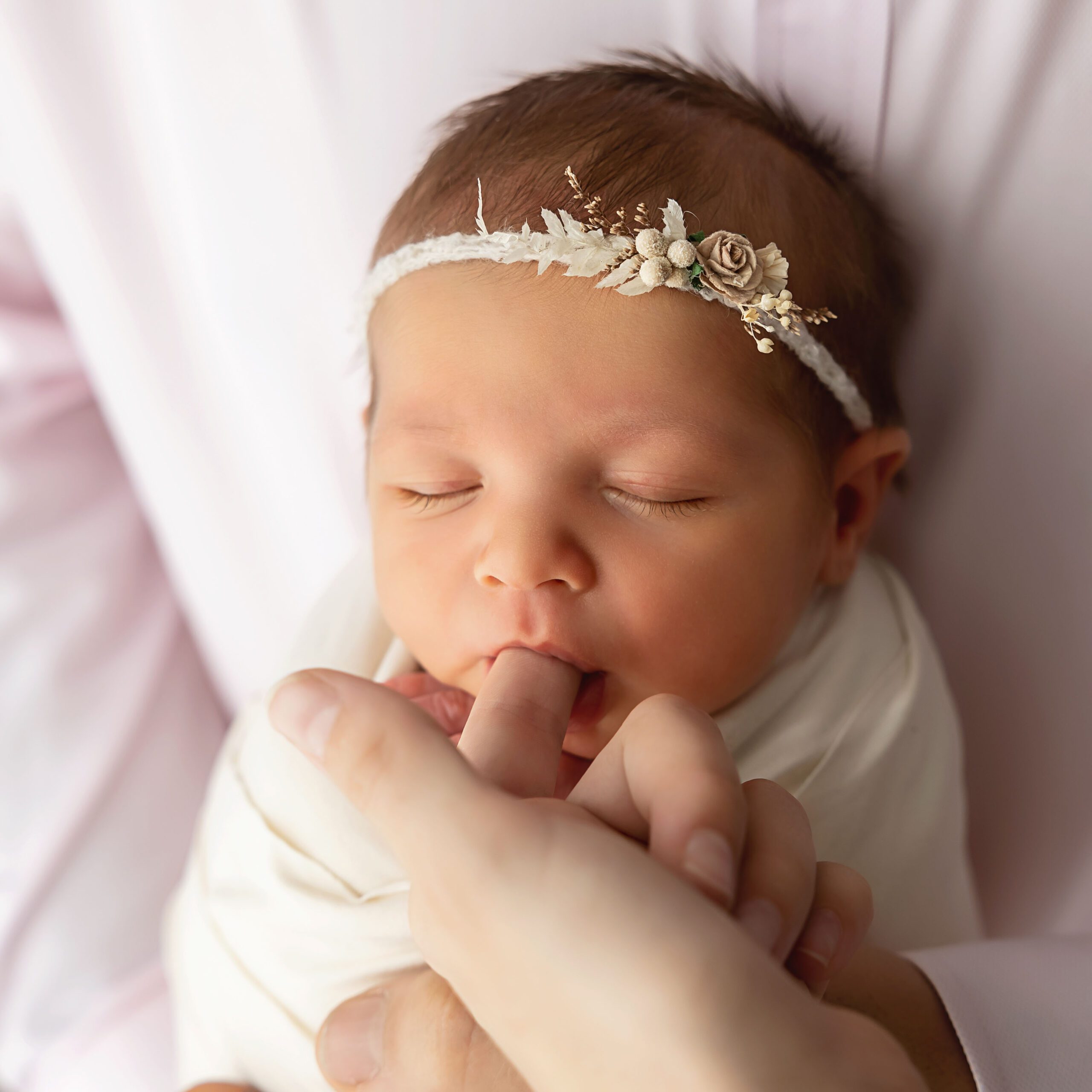 newborn girl sucking dads finger